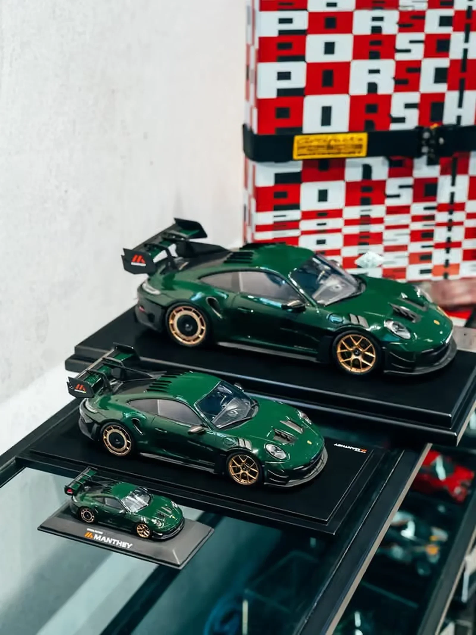Green Porsche 911 collectible scale models displayed in three sizes